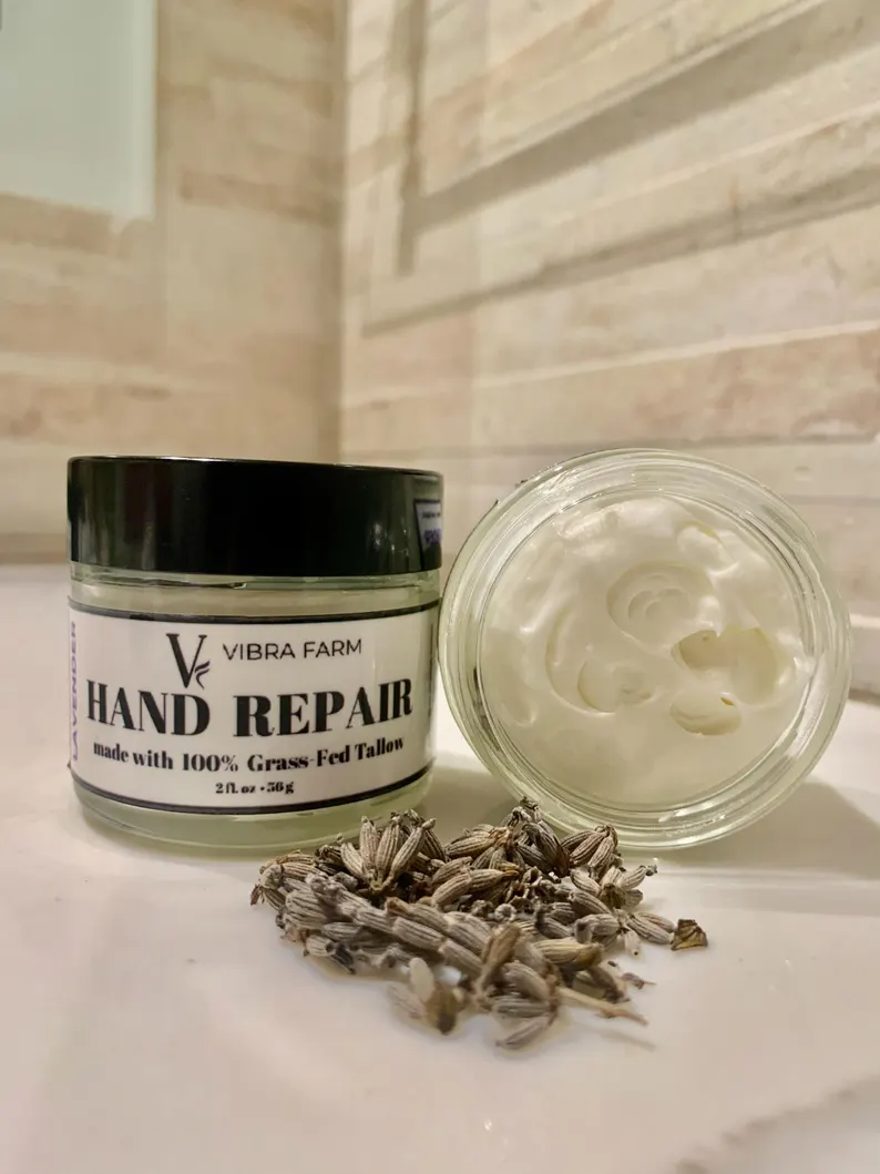 Natural Lavender Tallow Hand Cream on a white marble bathroom counter with white stone wall in the background.