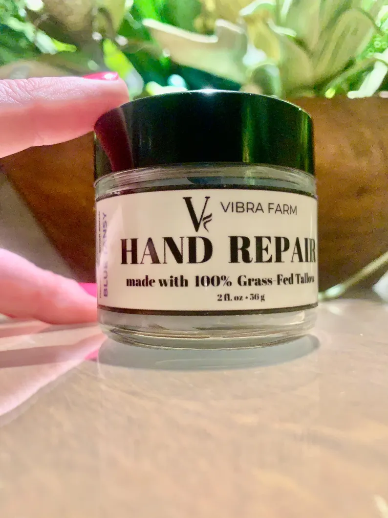 Natural Lavender Tallow Hand Cream on a white marble bathroom counter with a house plant in the background.